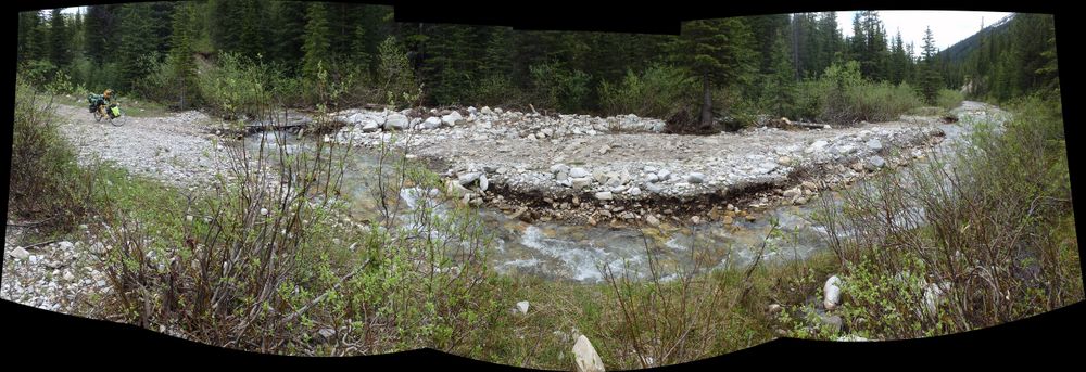 GDMBR: Downstream, the creek is running straight down our road to travel - The road is flooded downstream.